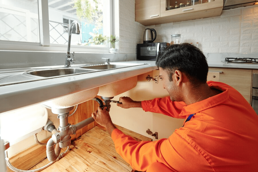 plumber unscrewing water pipe
